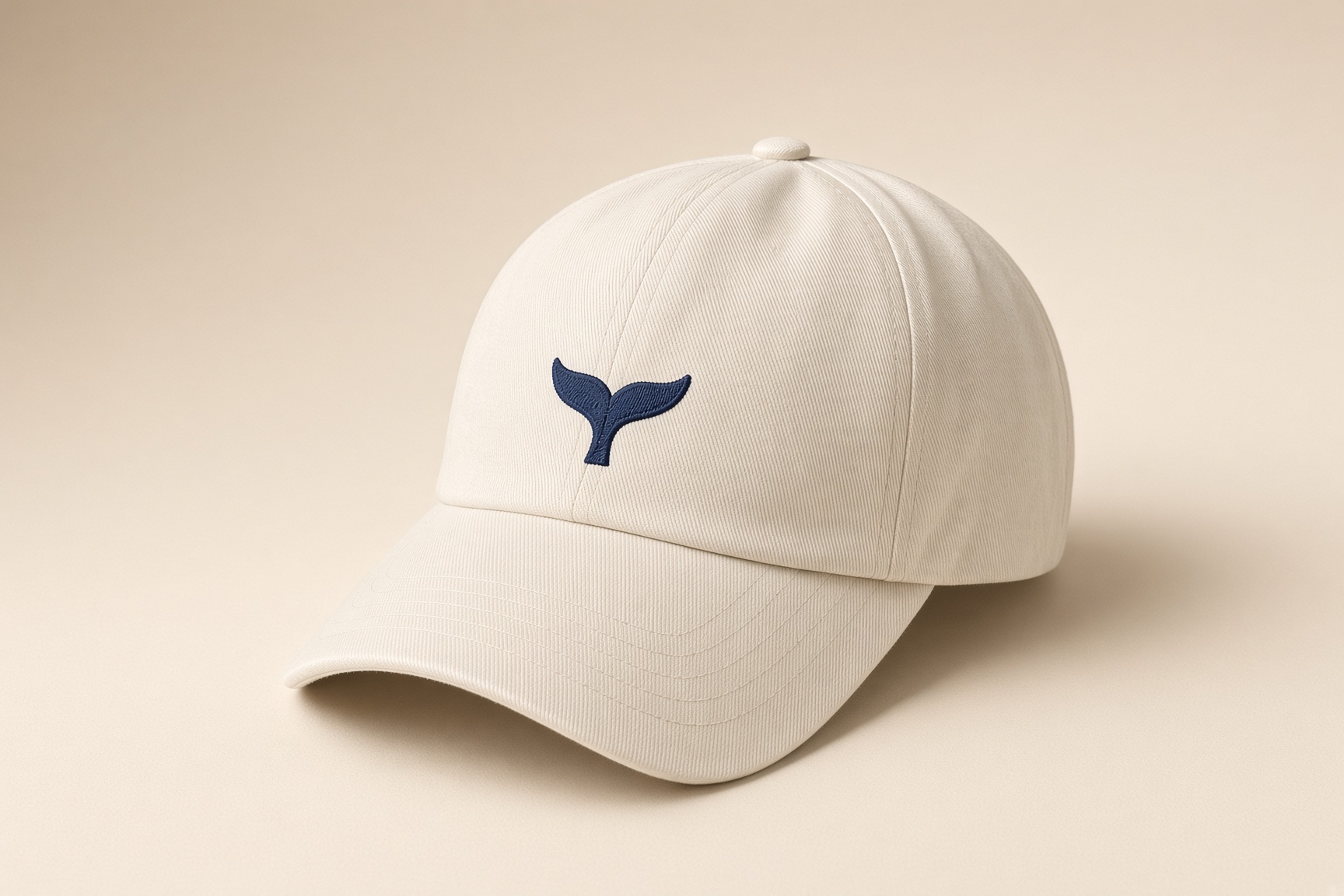 Cream cap with a navy whale fluke on the front