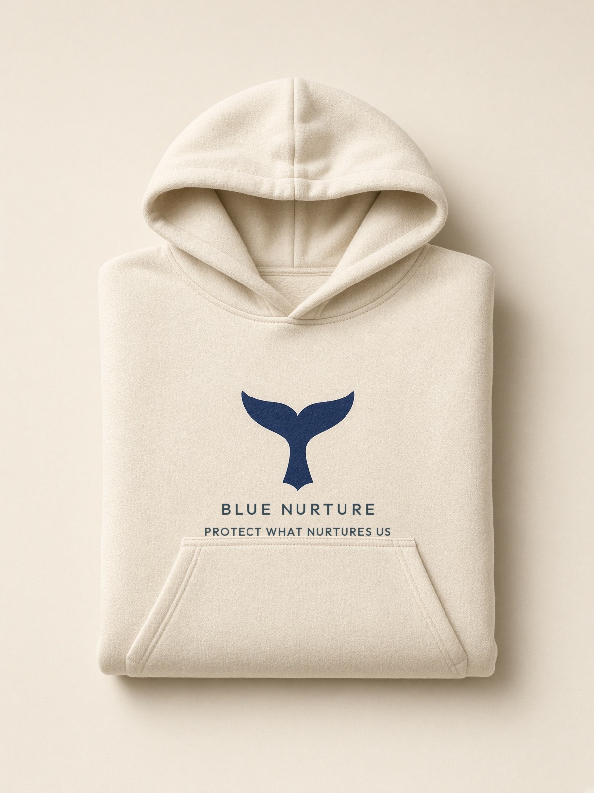 Folded cream hoodie with the navy fluke stack on the chest